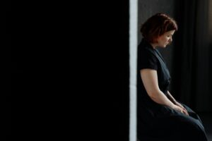 side view of a depressed woman in a black dress